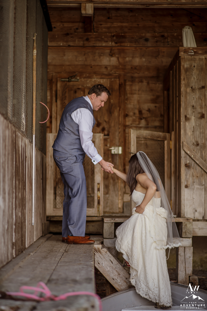 Groom helping bride into boathouse in Interlaken Switzerland