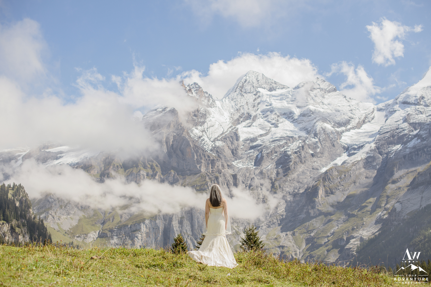 Bride standing in front of the Swiss Alps