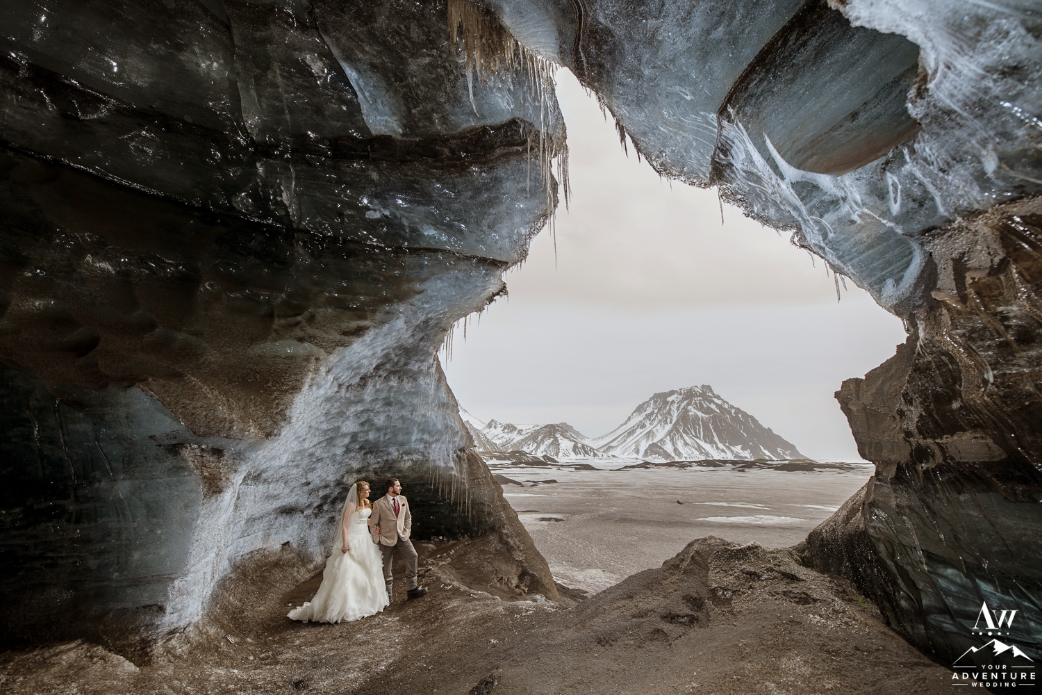 Couple Standing inside of an ice cave during Iceland wedding day adventure