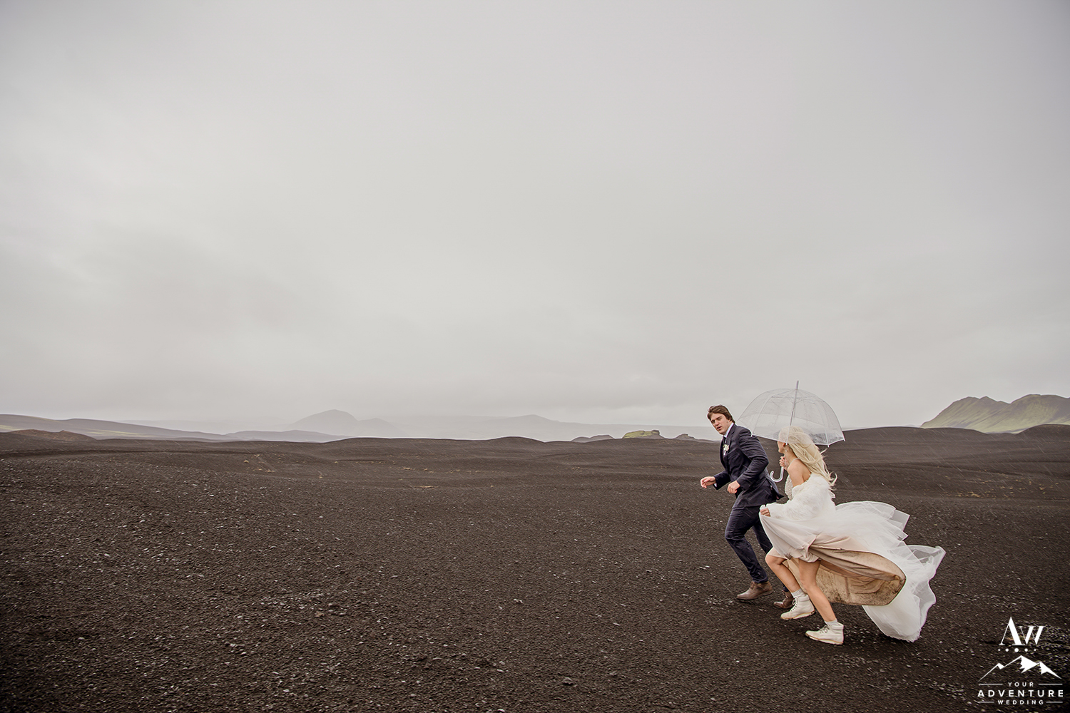 Couple Running through Rain during their Iceland Elopement