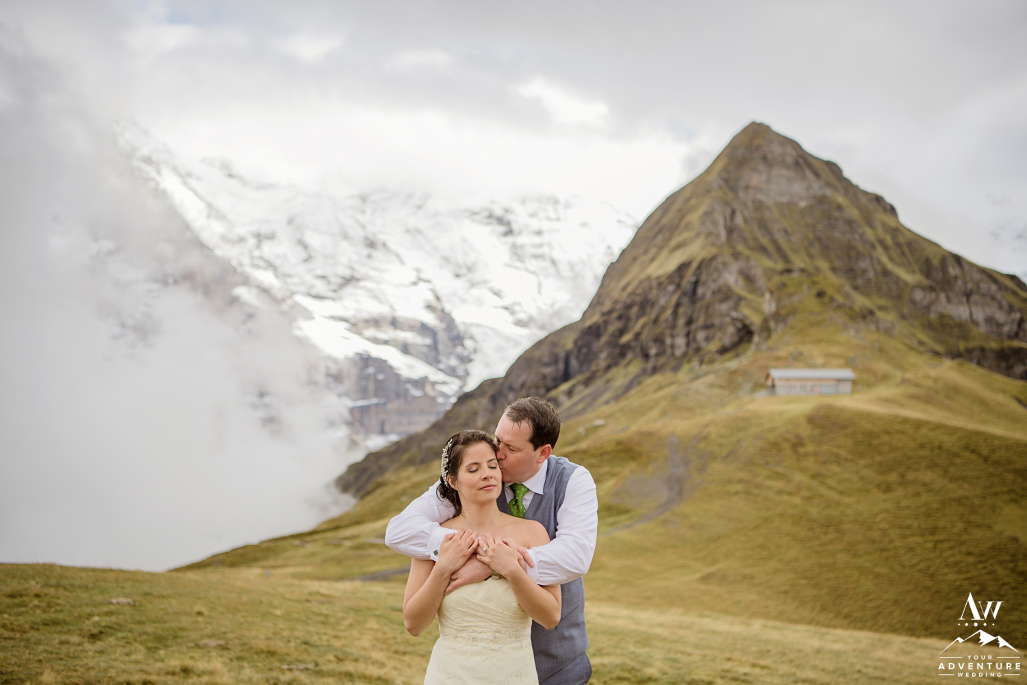 Groom Kissing his bride on Männlichen in Switzerland