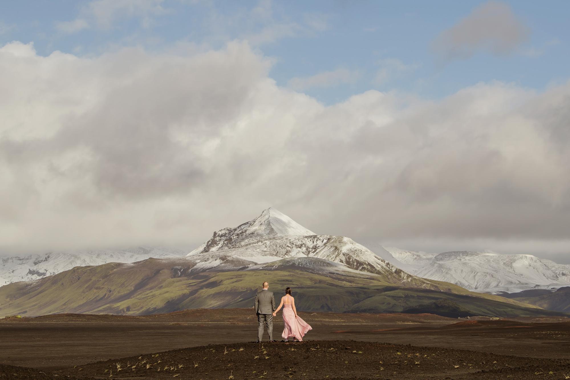 Bride in pale pink elopement dress with groom against mountainous landscape