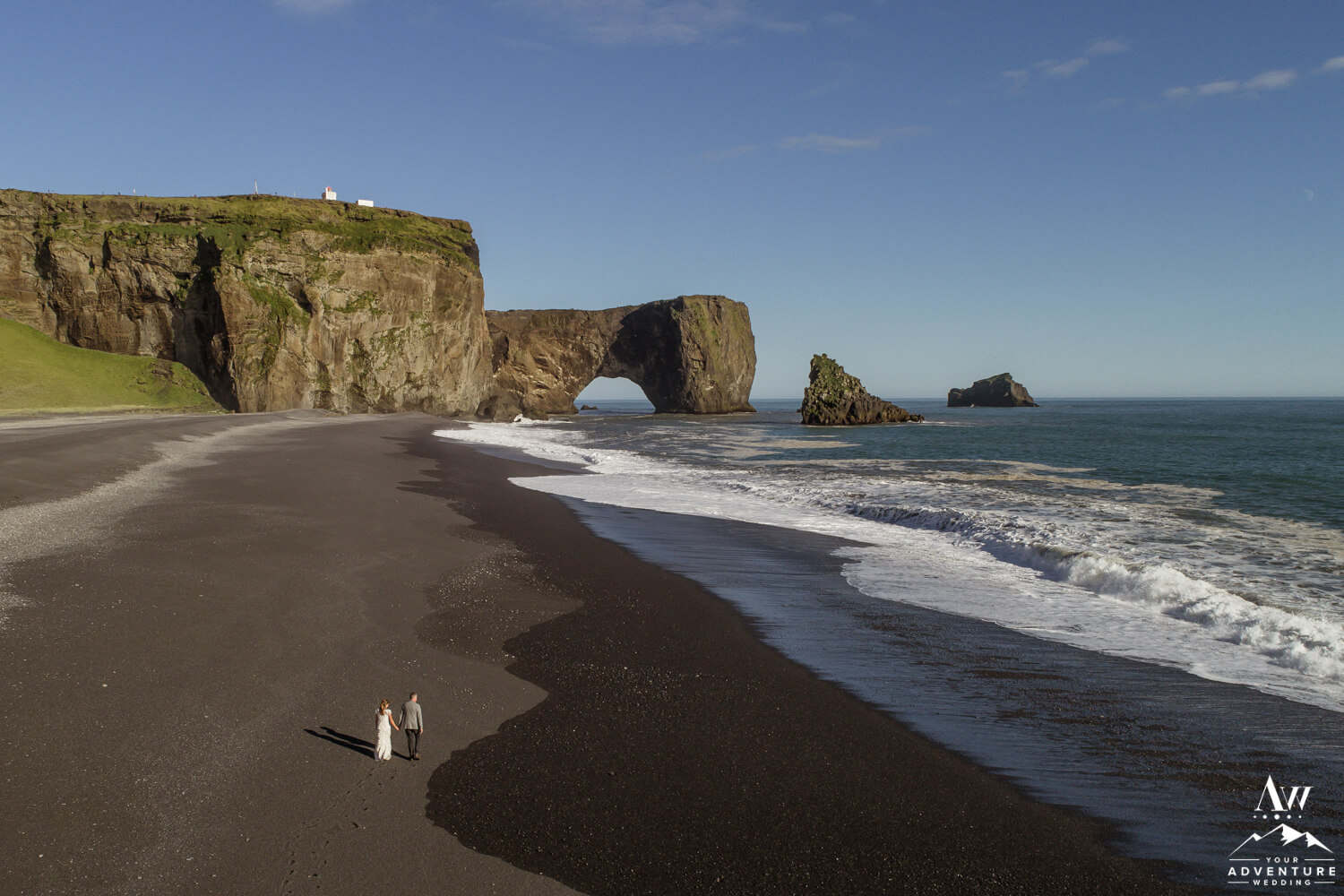 Elopement Budget - Couple walking on black beach