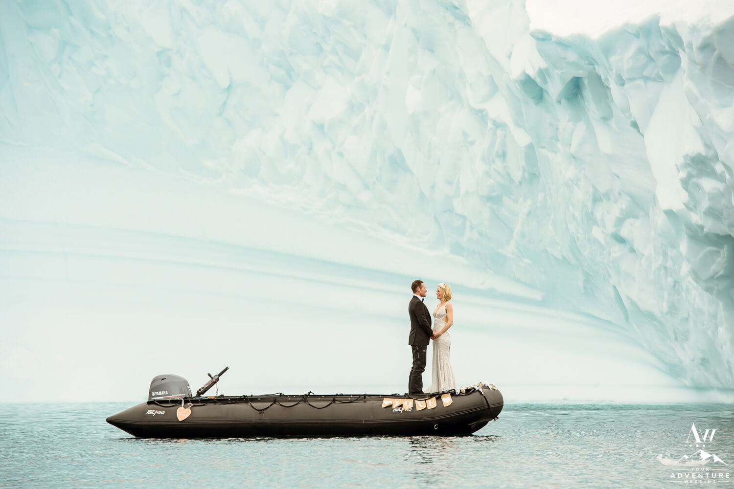 Antarctica elopement couple in a zodiac in front of an iceberg